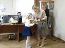 Директор Государственного архива Астраханской области Мария Полякова вручает экземпляр книги астраханской школьнице