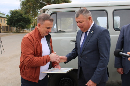 Андрей Мельниченко передаёт Руслану Бисенову документы на автомобиль